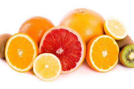 A display of vibrant citrus fruits including oranges, grapefruit, lemon, and lime, alongside kiwis, showcasing natural sources of vitamin C.