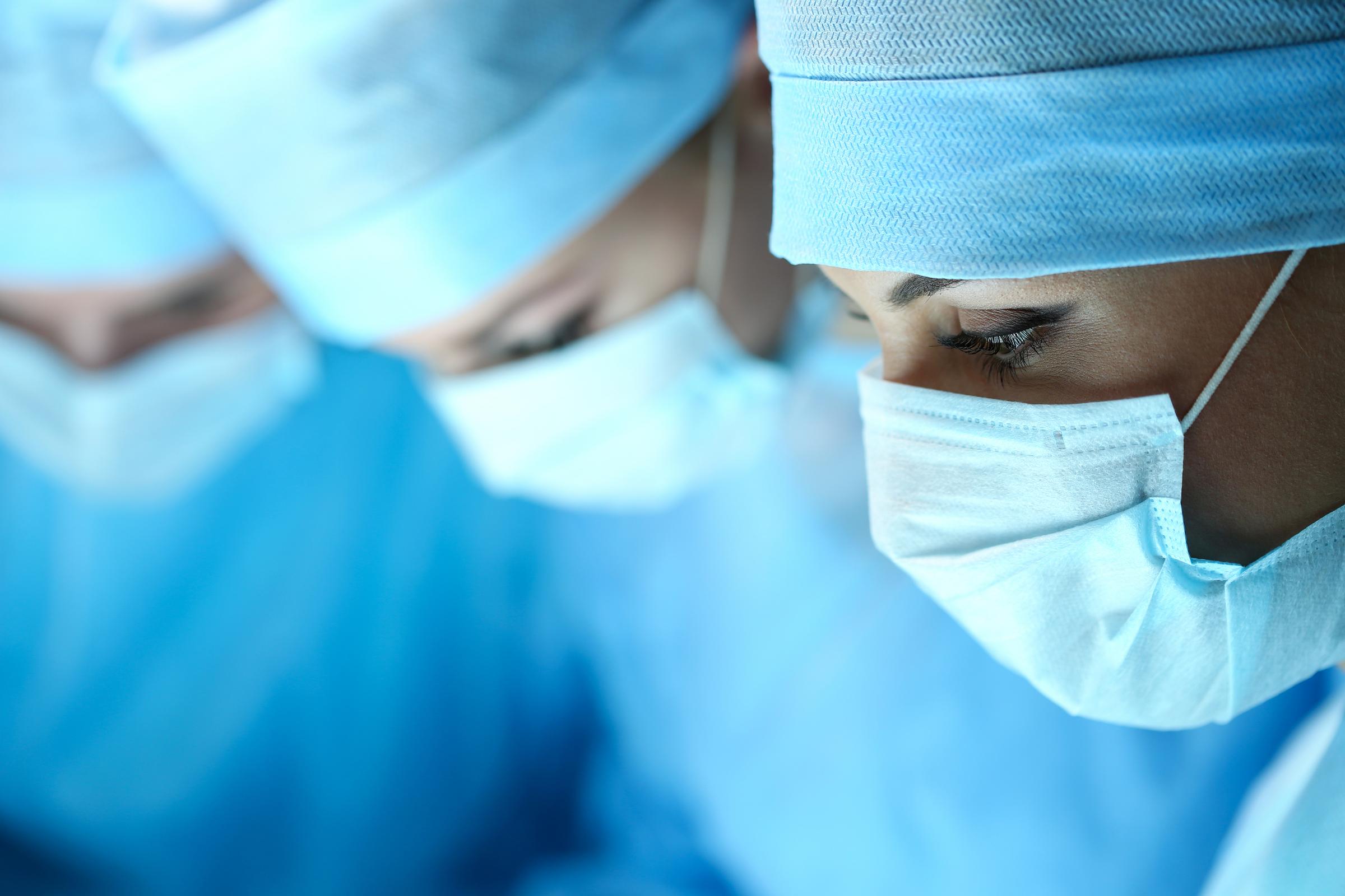 Doctors and Nurses Performing Surgery - shutterstock