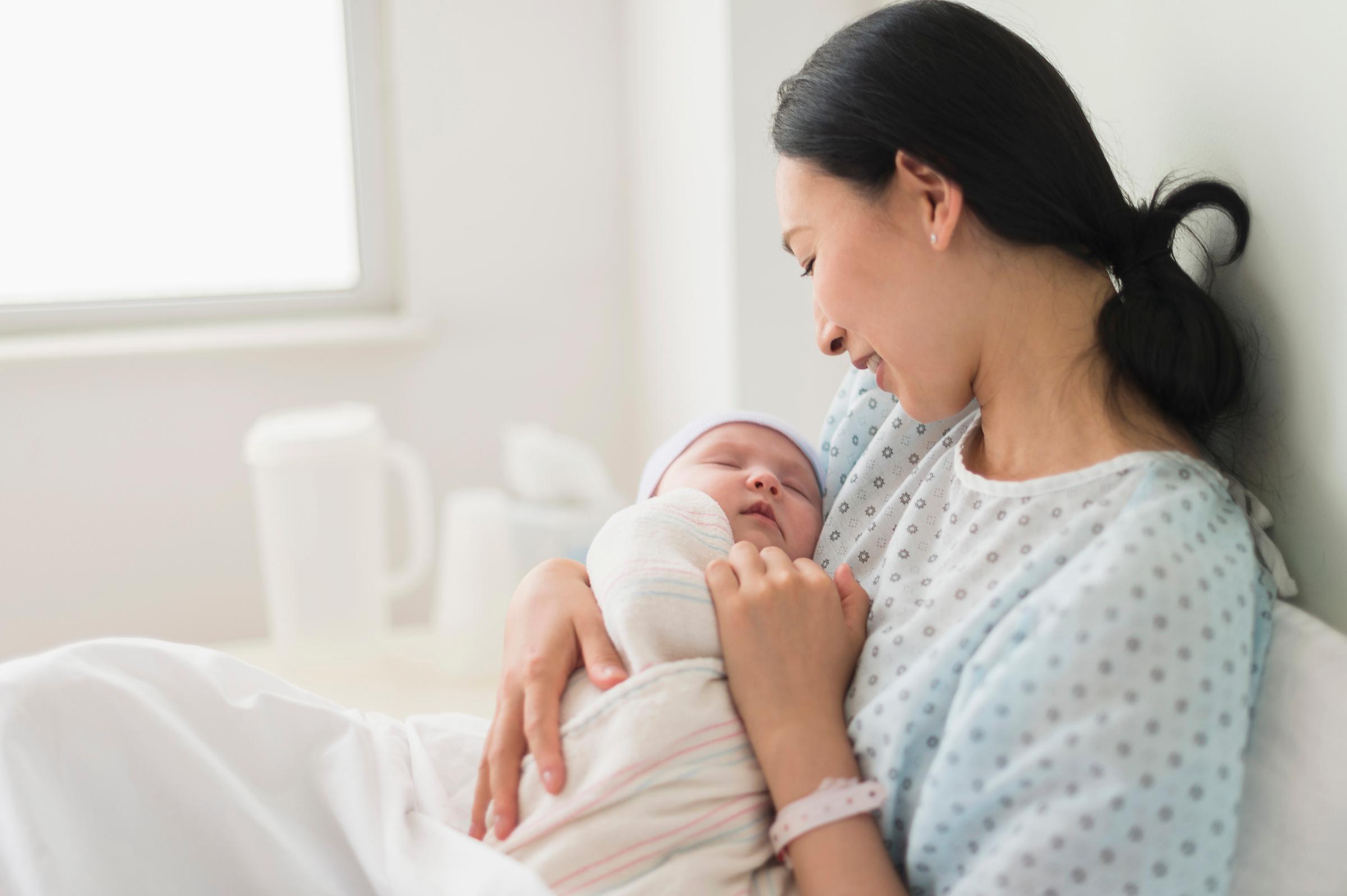 Asian Woman Holding a Baby - GettyImages