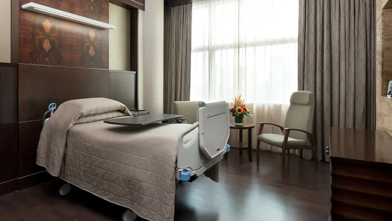 A large single bed and hotel-like ambience within Mount Elizabeth Novena Hospital's Junior Maternity Suite