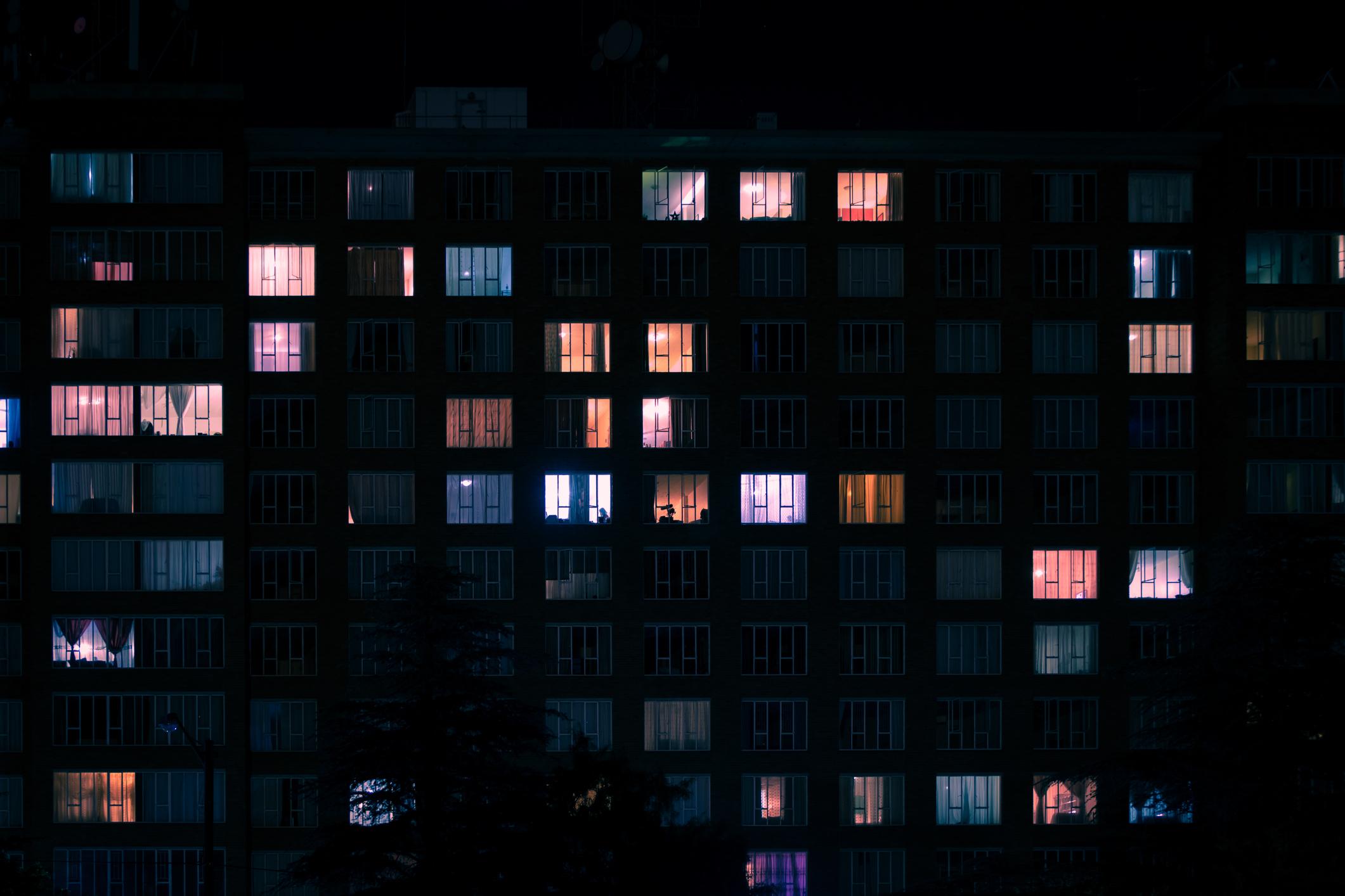 Large building with many windows showing different coloured lights