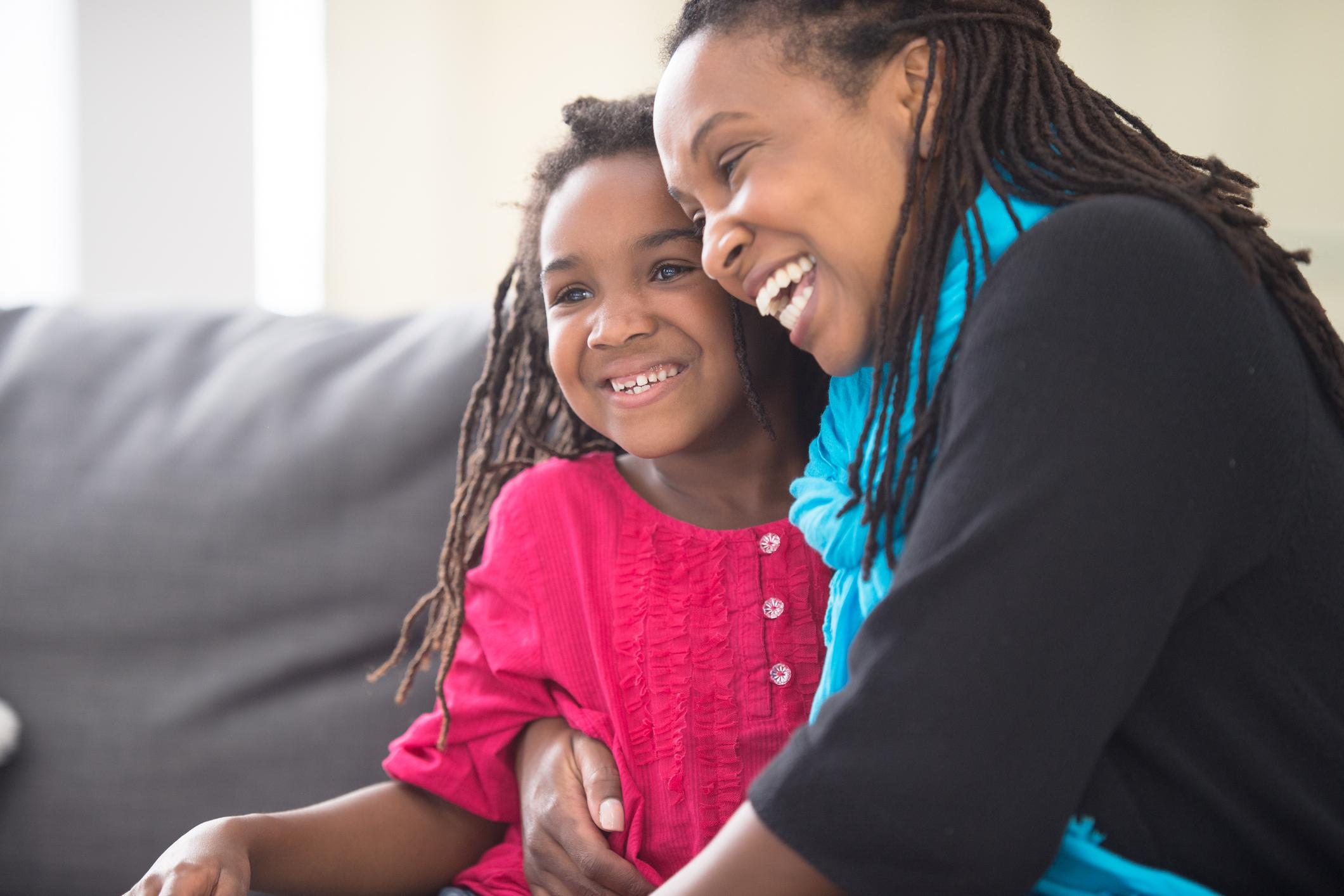 Mother and daughter sat together smiling.