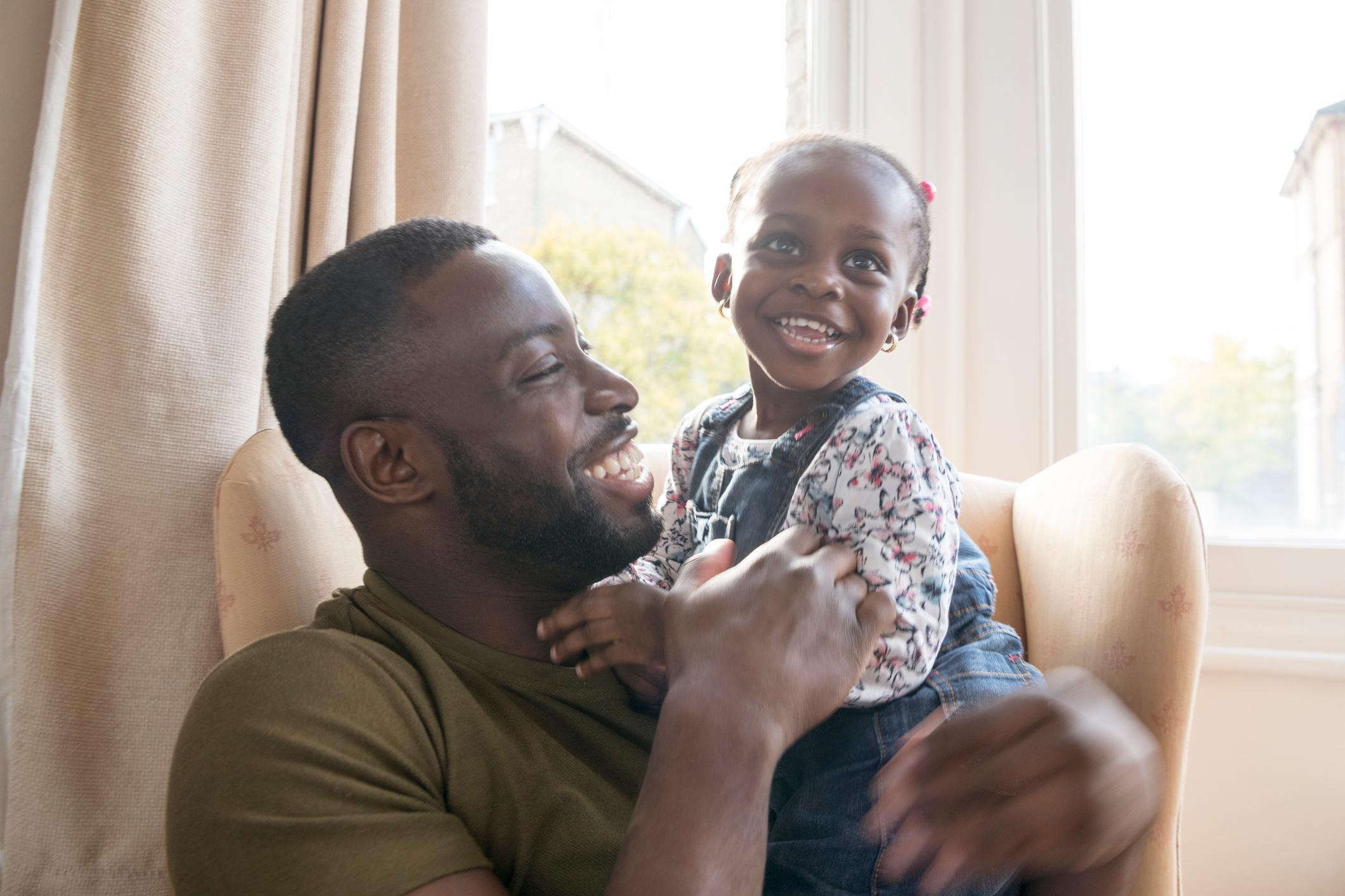 Father and daughter sat together smiling.