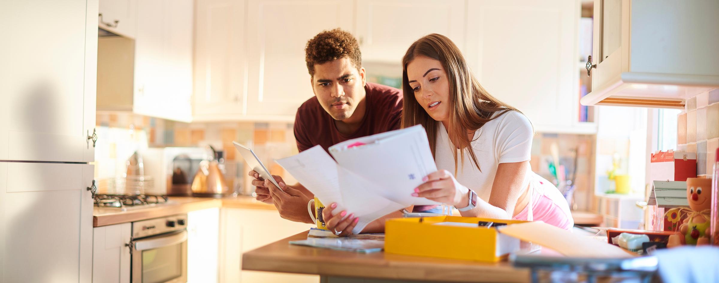 A young couple looking through their household bills.