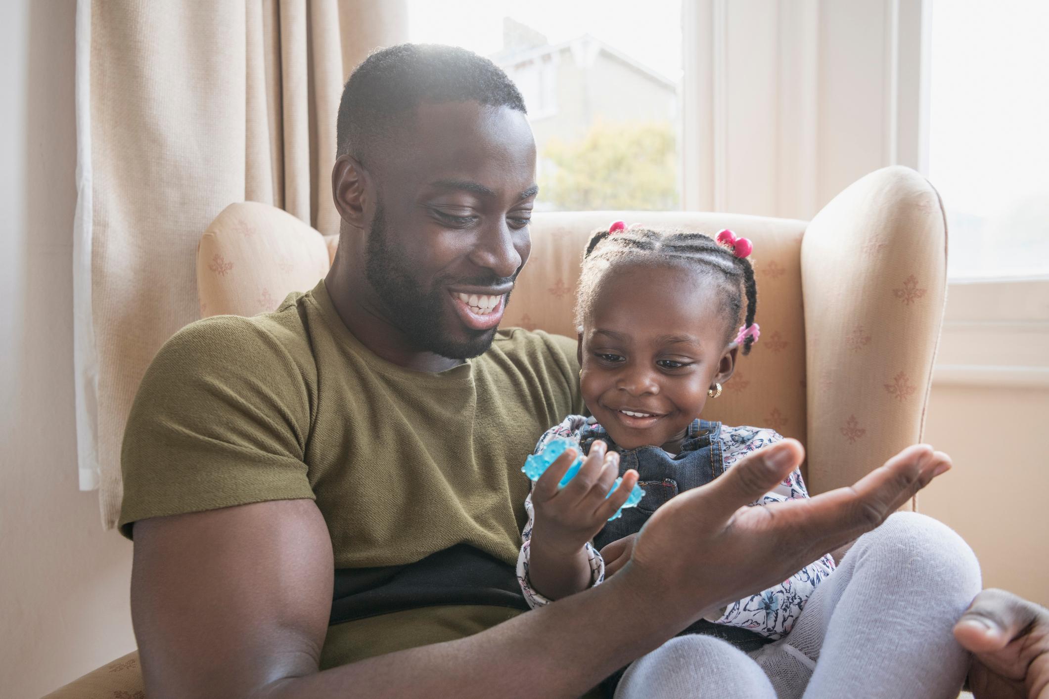 Father and daughter sat together smiling.