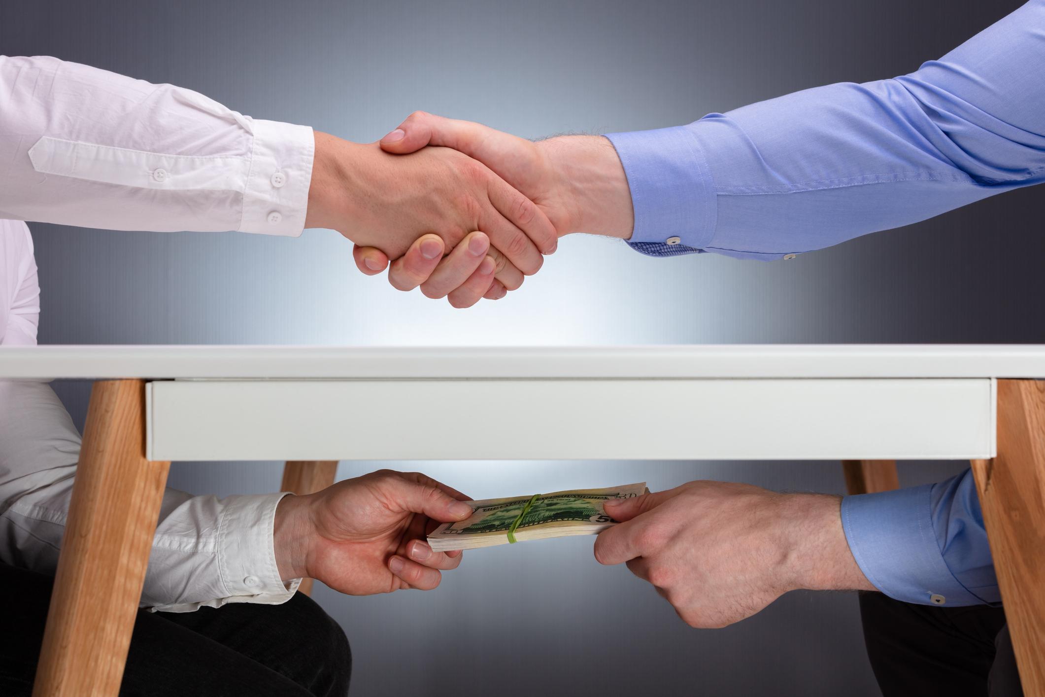 Businessmen Shaking Hands After The Business Deal Receiving A Bribe Money Under The Table