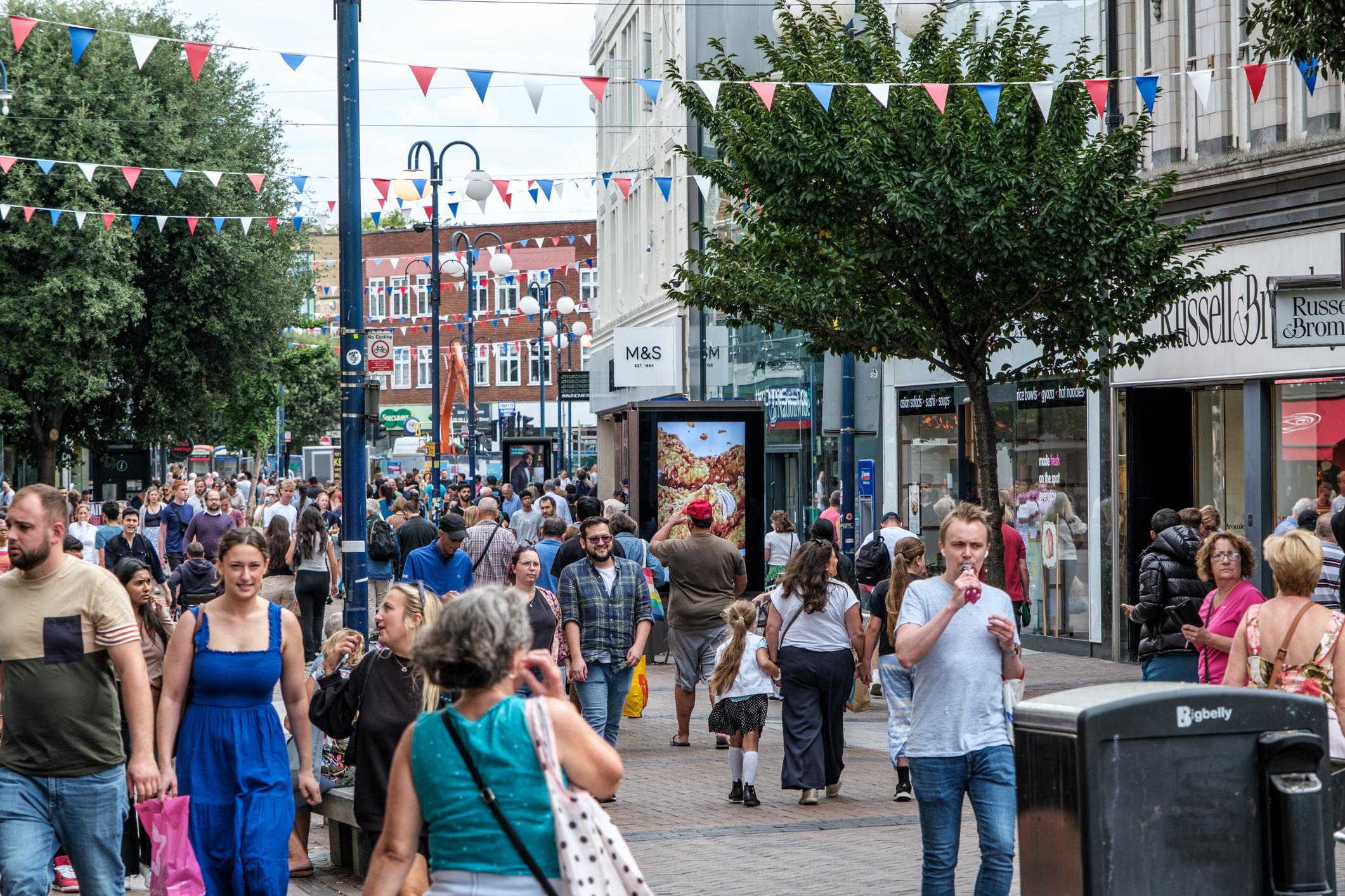 Shoppers walking along a street in Kingston-Upon-Thames.