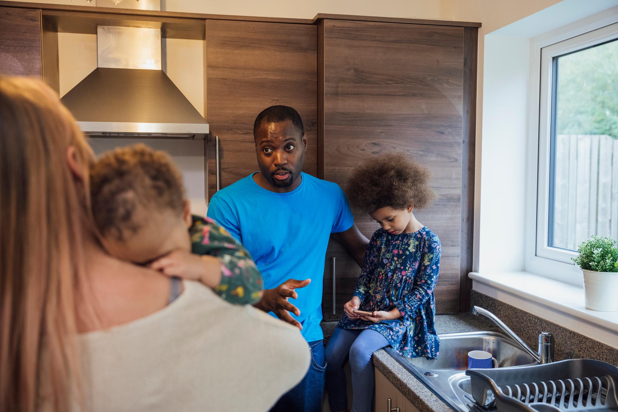 Family conversing in a kitchen.