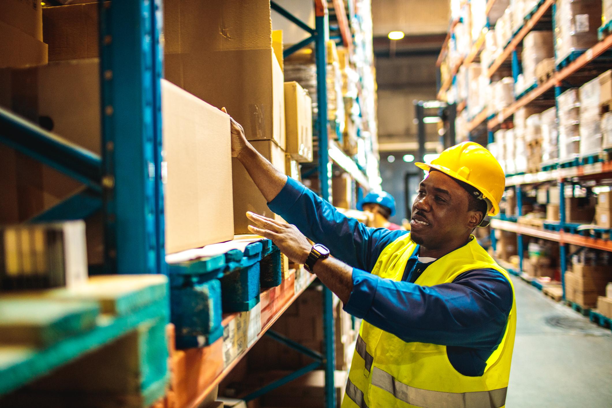 Two warehouse workers moving boxes.