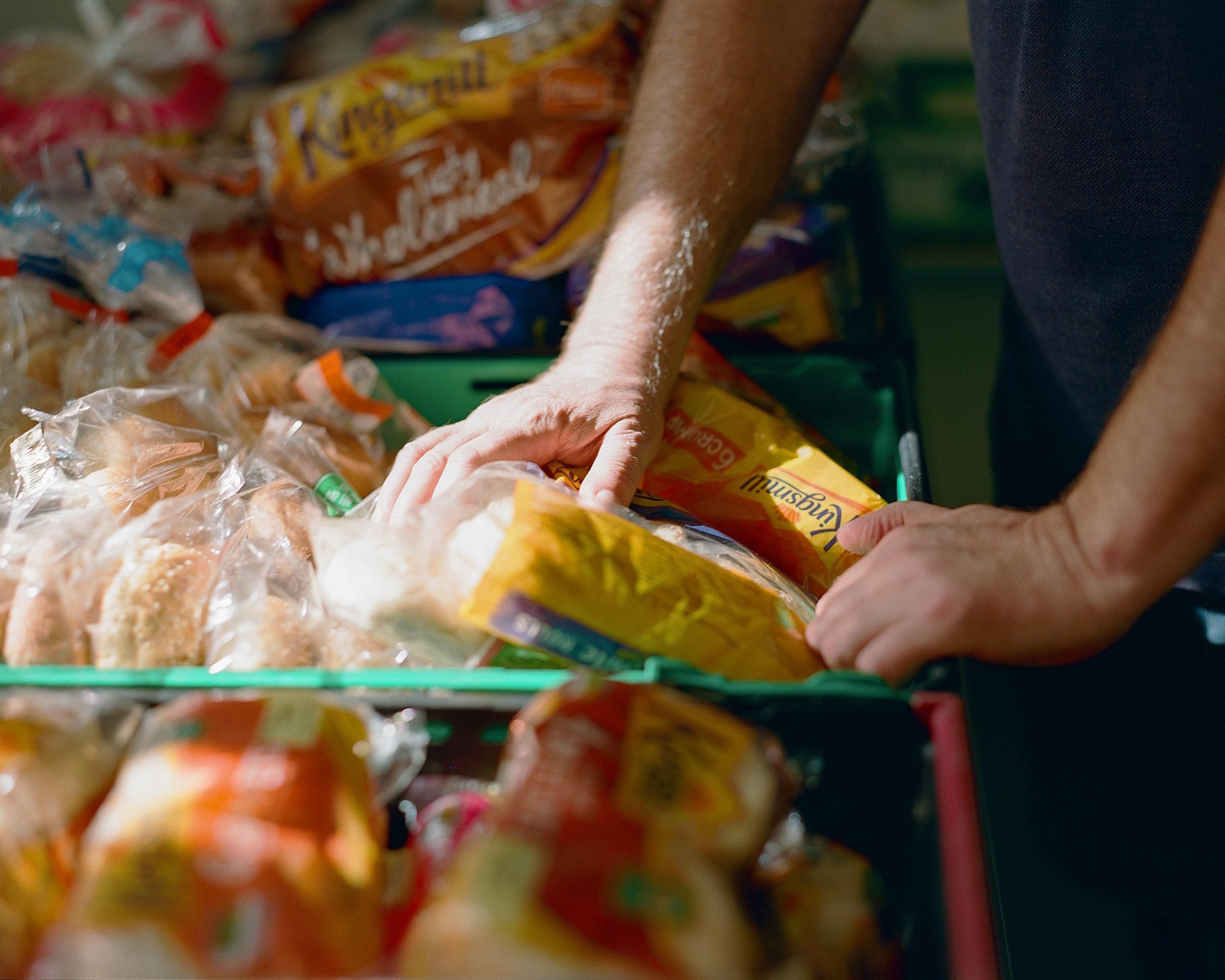 Food bank worker sorting a bread delivery.