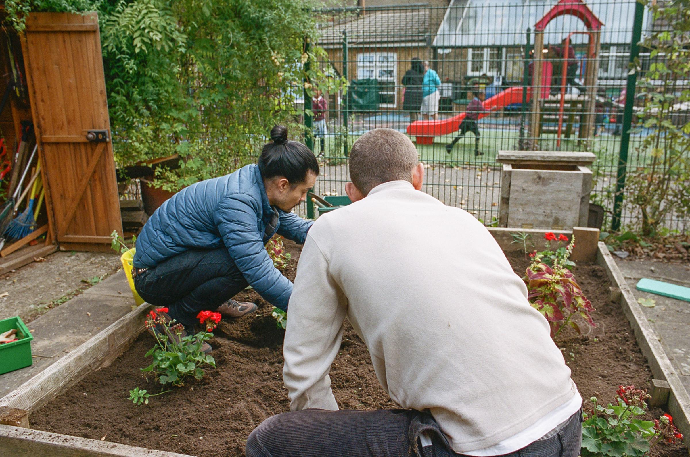 Volunteers tidying a school garden.