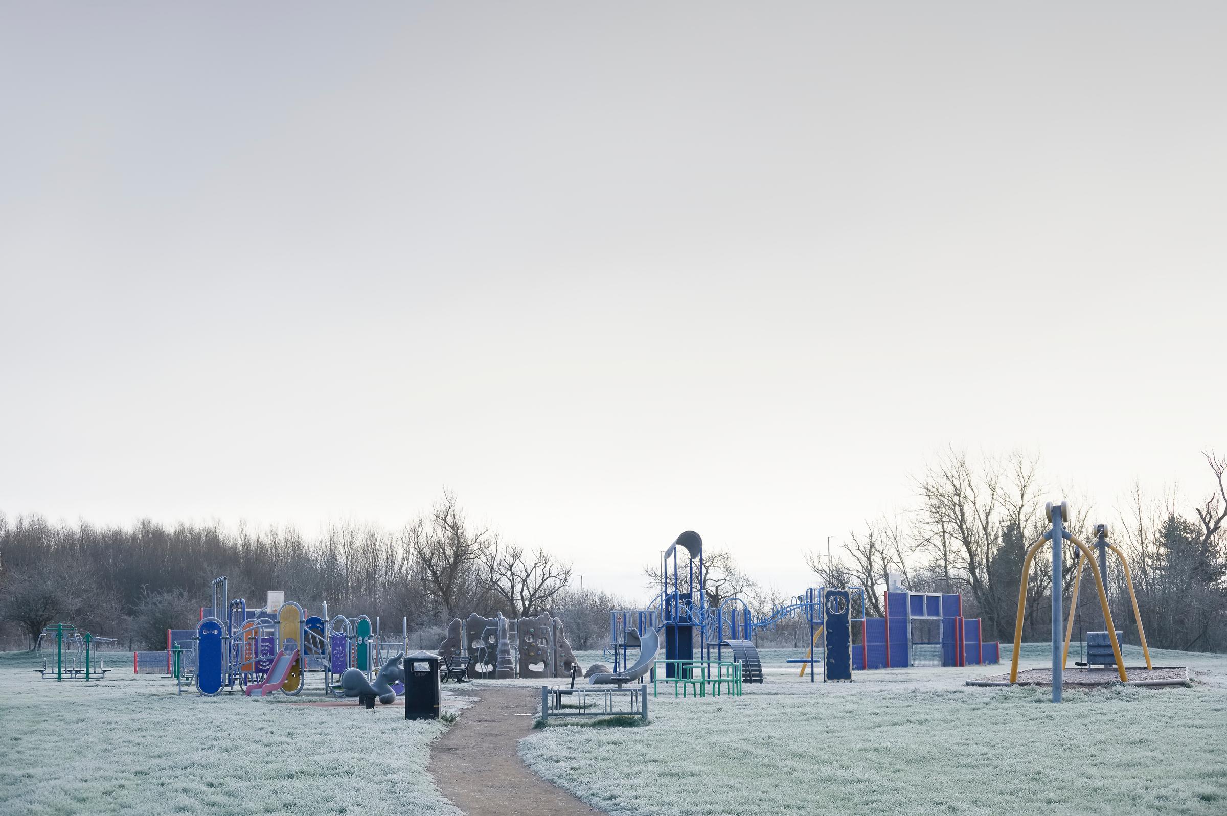 Playground with frozen grass during winter in the UK.