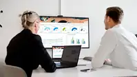 Two people in meeting room looking at graphs and diagrams