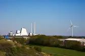 View of Avedore power plant with view of green nature and wind turbine