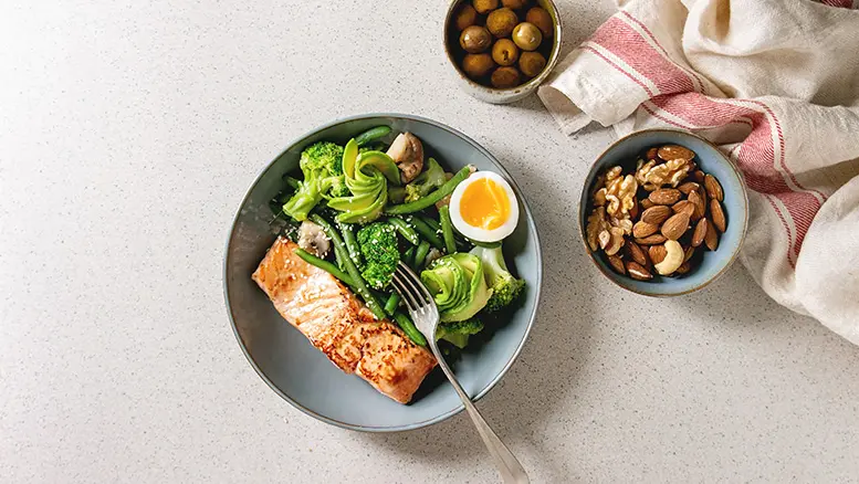 Picture of a healthy meal comprising salmon, salad and nuts.