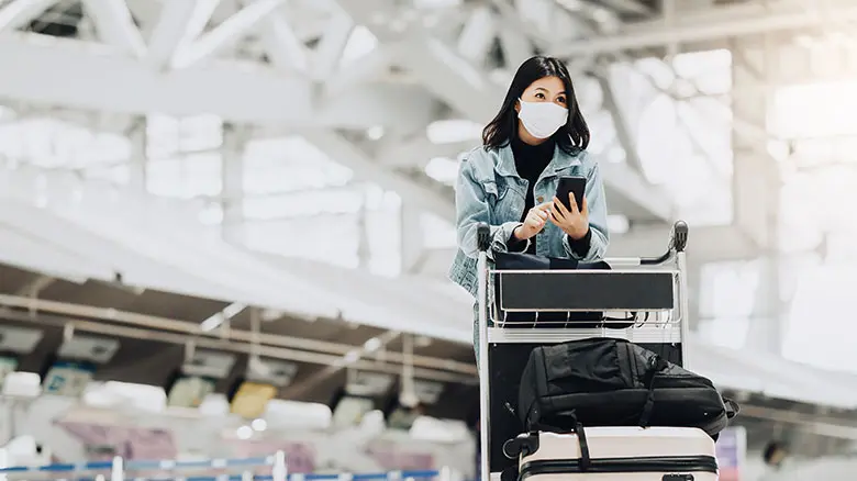 Woman traveler with luggage trolley