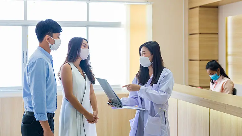 Dokter berbincang dengan pasangan suami istri tentang perencanaan keluarga di rumah sakit. Dokter berbincang dengan pasangan suami istri tentang perencanaan keluarga di rumah sakit. Stock Photo Pasangan - Hubungan