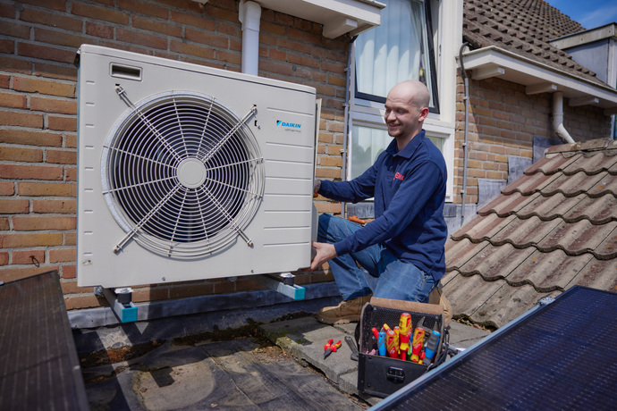 Een Eneco monteur installeert een warmtepomp