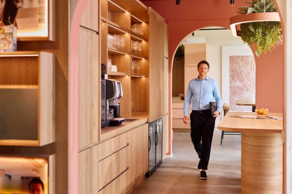 Zakelijk man loopt met een laptop onder zijn arm