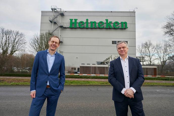 Two men in front of the Heineken building