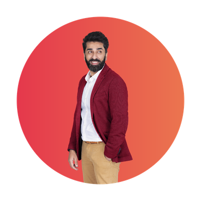 Een man in een rode blazer glimlacht zelfverzekerd tegen een verloopachtergrond.