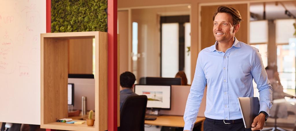 Zakenman loopt met een laptop onder zijn arm