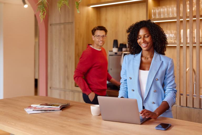 Lachende zakenvrouw achter haar laptop