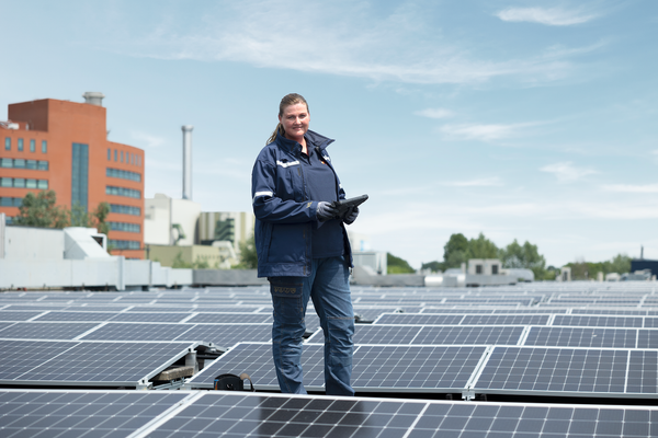 Vrouwelijk Eneco monteur op het dak met zonnepalen