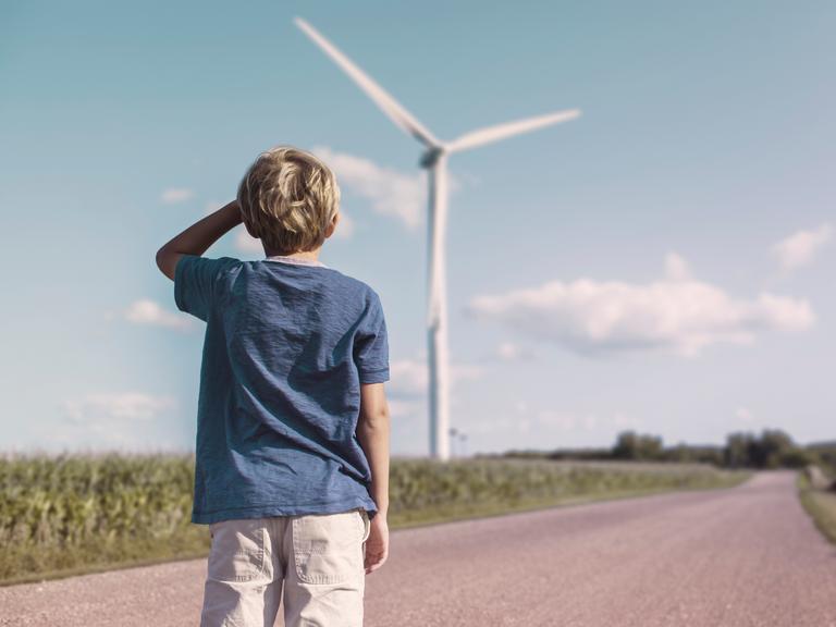 Boy looking at wind turbine