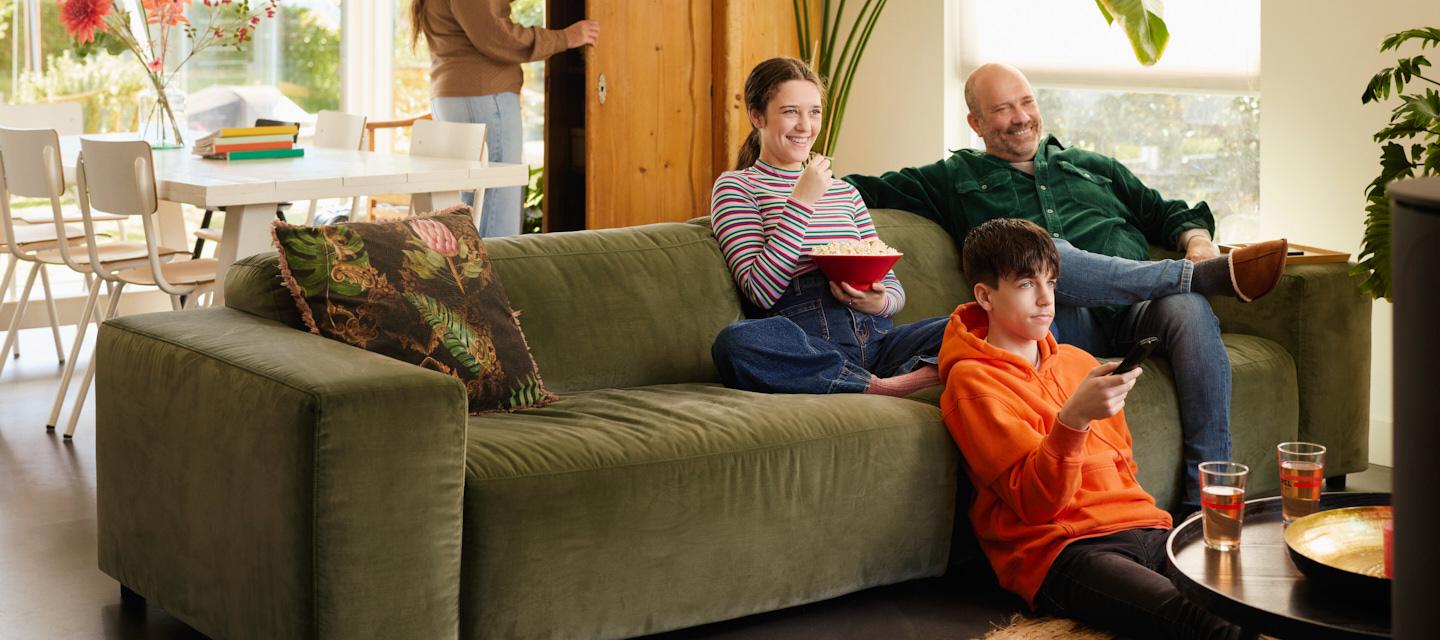 Gezin zit op de sofa en kijkt TV