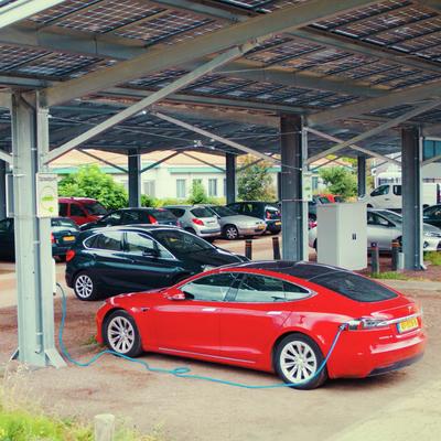 Auto gekoppeld aan een laadpaal onder een solar carport