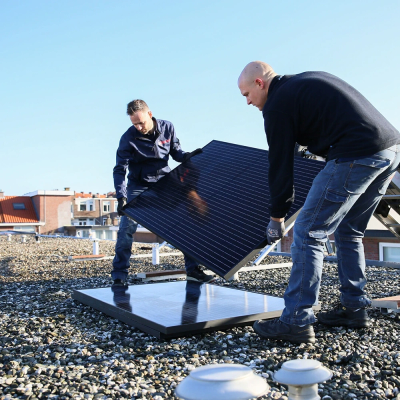 Monteurs installeren zonnepanelen op plat dak