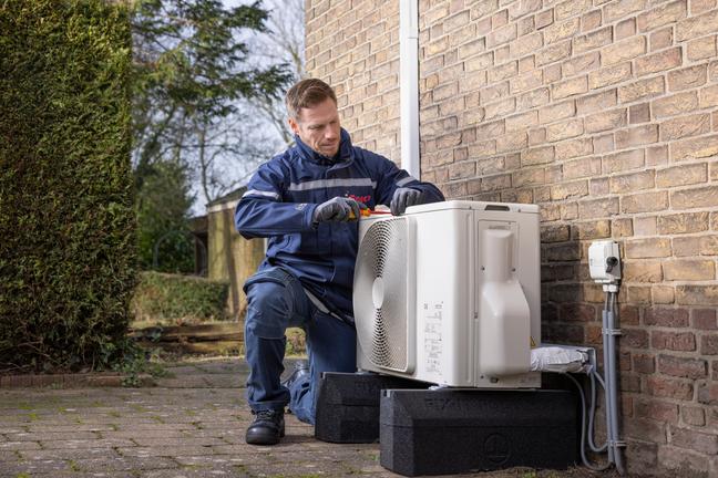 Monteur installeert hybride warmtepomp in een bestaande woning