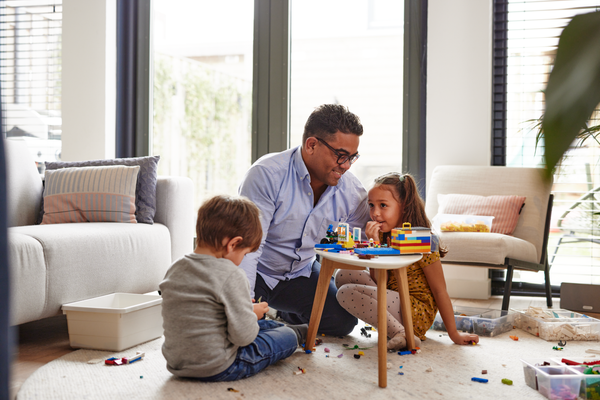 Vader met kinderen aan het spelen in woonkamer