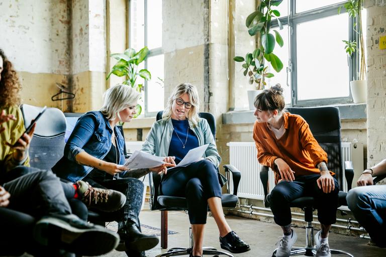 Drie vrouwen overlopen samen wat er op een blad papier staat