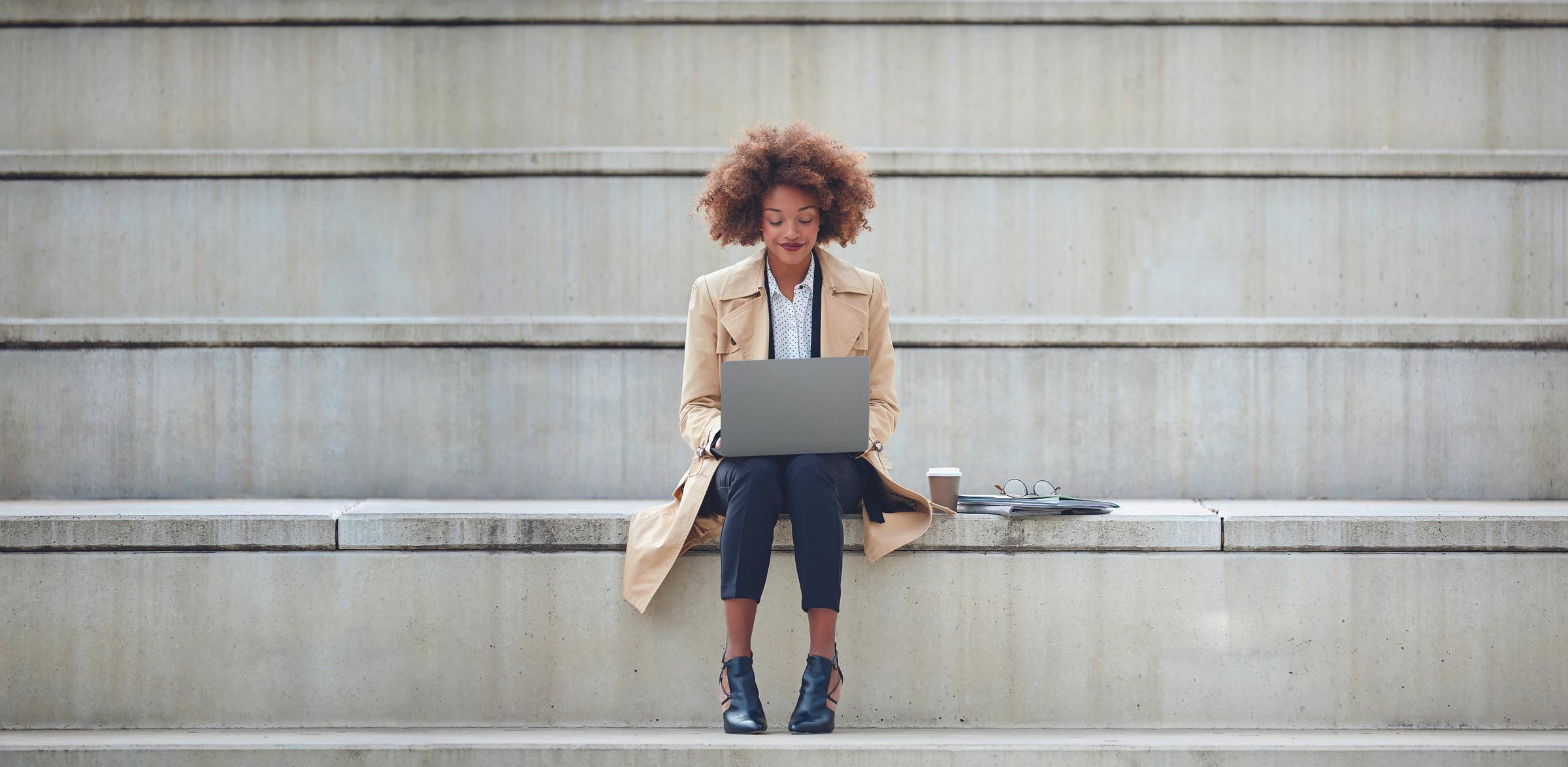 Woman with laptop on stairs