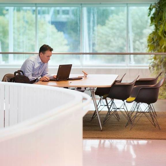 Man zit aan bureau op laptop te werken