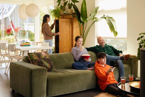 La famille regarde la télévision sur le canapé