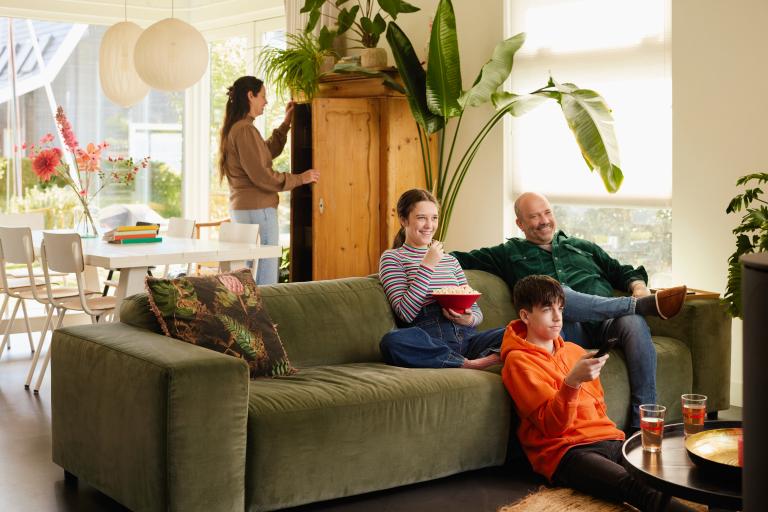 La famille regarde la télévision sur le canapé