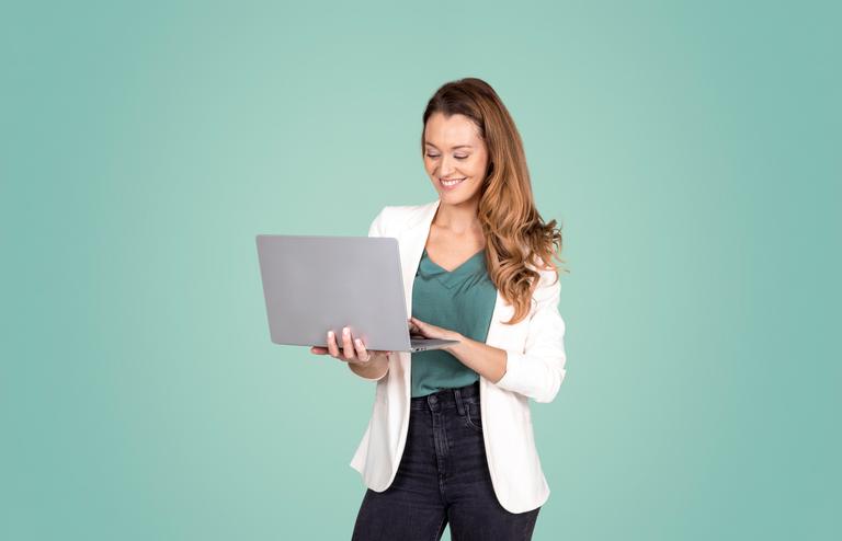 Vrouw kijkt lachend naar haar laptop