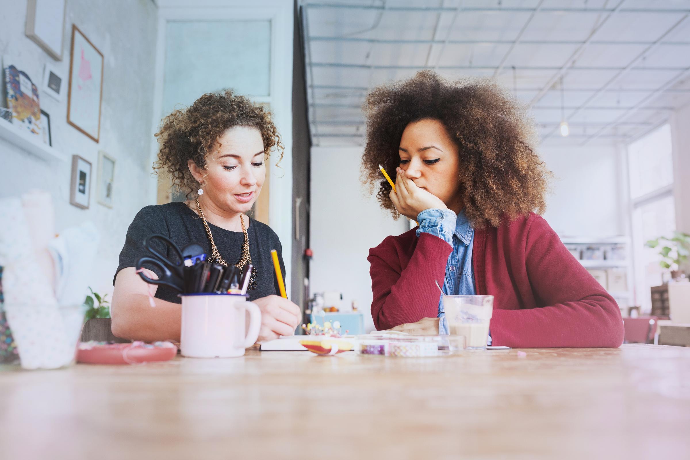 Twee vrouwen aan bureau werken samen aan een project