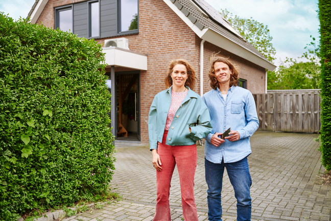 Een stel staat voor hun huis