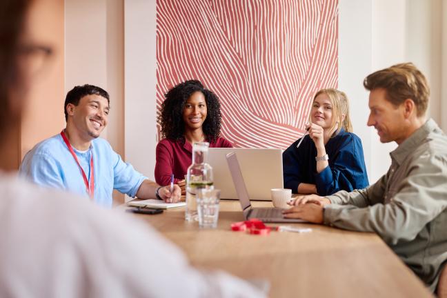 Vergadering rondom tafel met collega's 