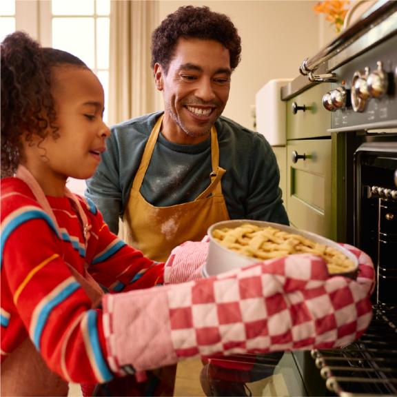 Vader en kind stoppen taart in oven