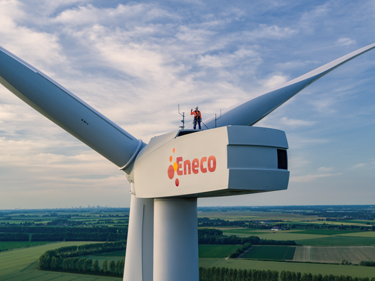 Drone foto van Eneco monteur op een windturbine