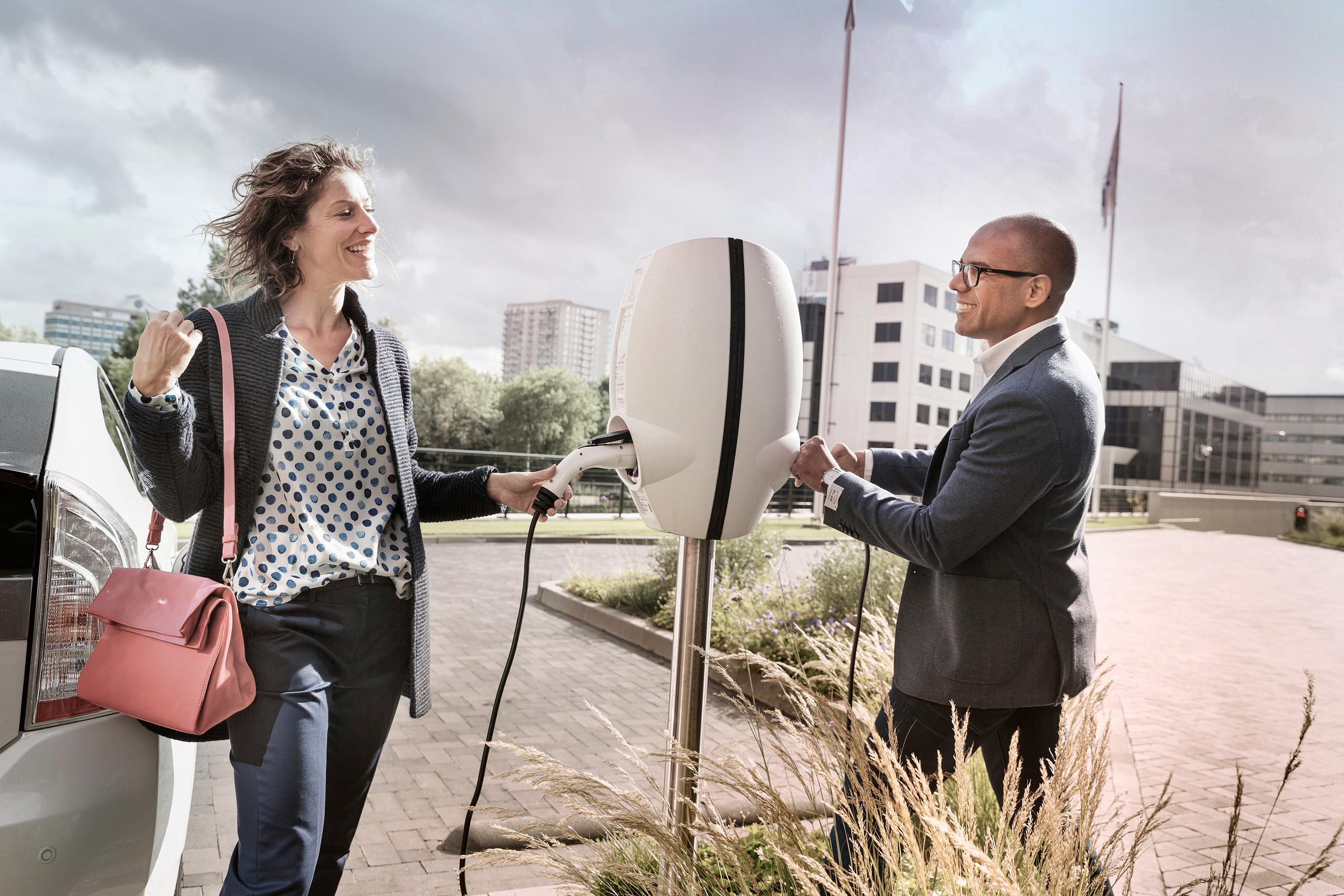 Man en vrouw met stekker in laadpaal