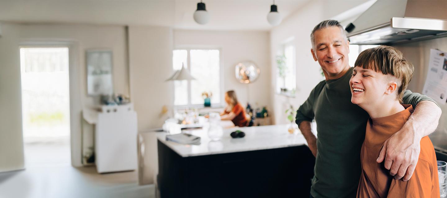 Man slaat zijn arm rond de schouders van een lachend kind