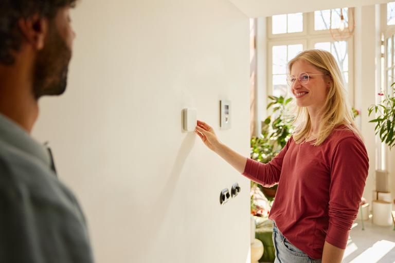 Vrouw stelt de slimme thermostaat in