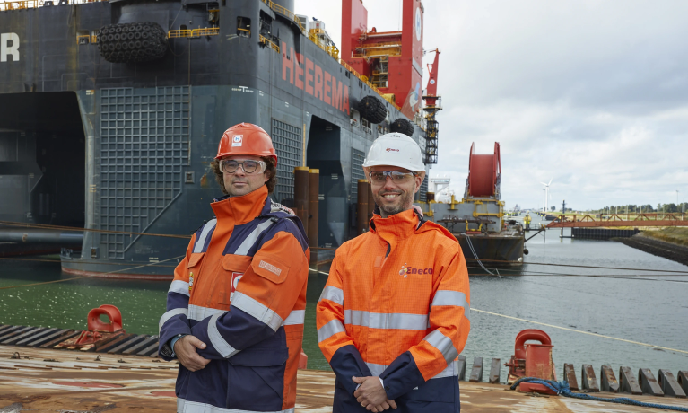 Twee lachende mannen in in oranje overall 