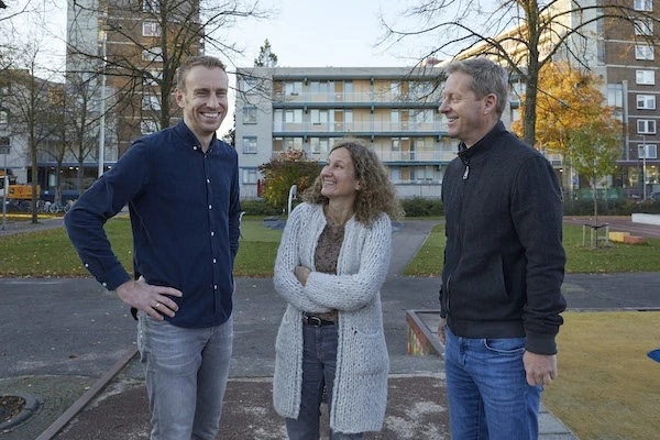 Mensen staan lachend in een Rotterdamse woonwijk